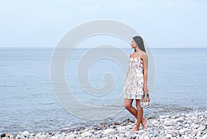 A young woman walking near the sea