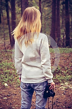 Young Woman walking with retro photo camera outdoor