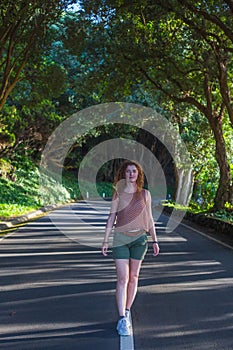 Young woman walking at the road in the forest near Vigia das Baleias. Terceira, Azores. Portugal photo