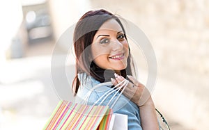 Young woman walking with shopping bags in hand