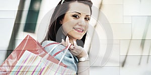 Young woman walking with shopping bags in hand, light effect, geometric pattern