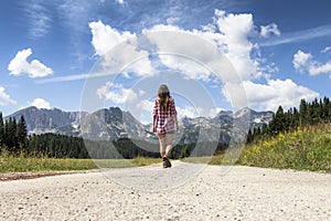 Young woman walking to the mountains