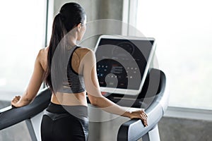young woman walking on treadmills in fitness gym