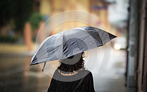 Young woman walking with umbrella in autumn day