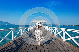 Young woman walking on wooden bridge in Si chang island, Thailand