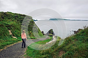 Young woman walks along pathway surrounded by irish landscape