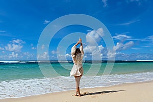 Young woman walks barefoot on the beach