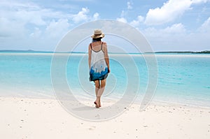 Young woman walks barfoot on deserted tropical island photo