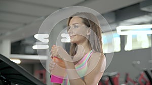 Young woman walks on a cardiovascular machine in the gym