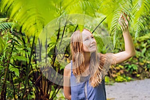 A young woman walks among the ferns