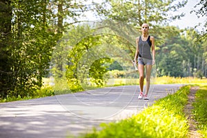 Young woman walks outdoor and listens to music