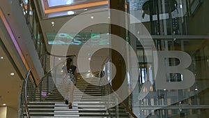 Young woman walks upstairs in modern building
