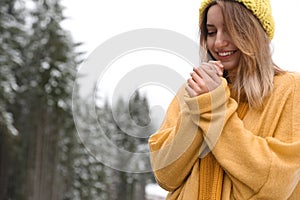 Young woman in warm clothes outdoors, space for text