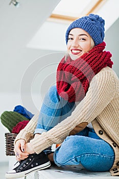 Young woman in warm hand knitted hat at home