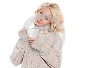 Young woman in a warm sweater and a mug in his hands