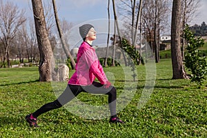 Young woman warming up and stretching before running