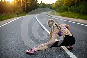 Young woman warms-up before Running on the road.