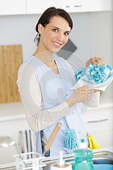 Young woman washing dish in kitchen