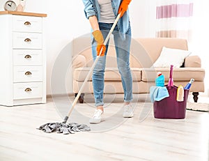 Young woman washing floor with mop in living room, closeup. Cleaning