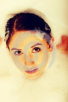 Young woman washing hair in bath