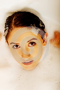 Young woman washing hair in bath