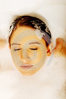 Young woman washing hair in bath