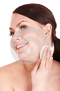 Young woman washing her face by sponge.