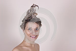 Young woman washing her head in the shower by shampoo