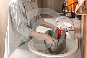 Young woman washing vegetables