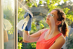 Young Woman Washing Windows. Beautiful young Housewife doing house chores