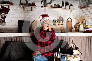 Young woman watching horror movies at home at night at christmas