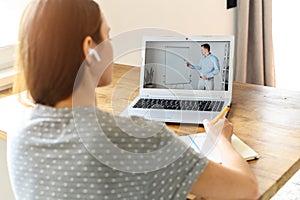 A young woman watching online classes at home