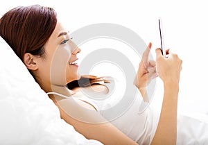 young woman watching smart phone on the bed