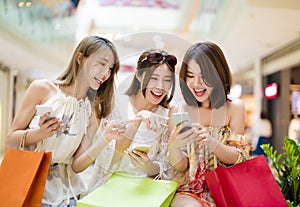 young woman watching smart phone in shopping mall