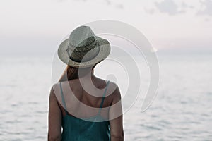 Woman watching sunset on the sea horizon