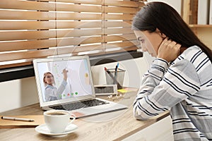 Young woman watching video at desk. Online learning