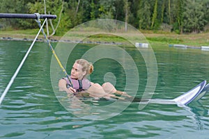 Young woman water skiing on slalom course