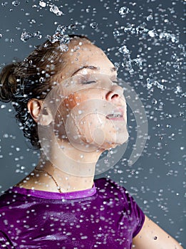 Young woman in water splashes and droplets