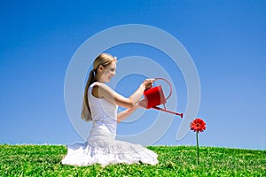 Mladá žena zalievanie kvetina 