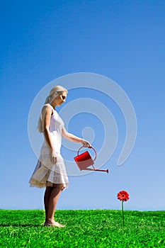 Young woman watering flower
