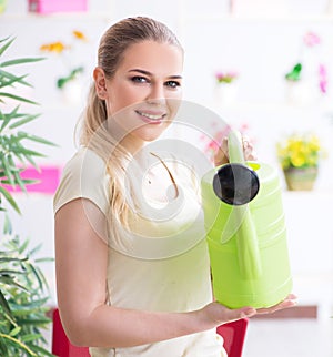 Young woman watering plants in her garden