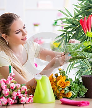 Young woman watering plants in her garden