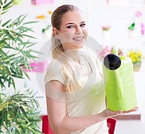 Young woman watering plants in her garden