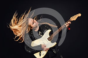 Young woman with waving hair play electric guitar