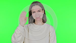 Young Woman Waving Hand to Say Hello on Green Background