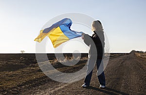 young woman with waving yellow and blue Ukrainian flag. request for help to Ukraine