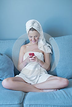 Young Woman Wearing Bath Towel with Red Cell Phone