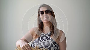 Young woman wearing beach dress, hat, sunglasses searching what to wear