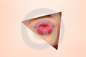 Young woman wearing beautiful lipstick, view through hole