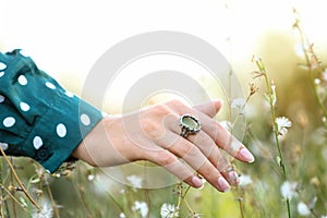 Young woman wearing beautiful silver ring with prehnite gemstone outdoors